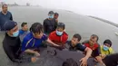 Relawan ThaiWhales dan dokter hewan berupaya menyelamatkan paus pilot jantan yang dalam kondisi sakit di pesisir pantai di Songkhla, Thailand, Sabtu (2/6). Sejumlah dokter hewan mencoba menstabilkan kondisi paus namun tidak berhasil. (AFP/ThaiWales)