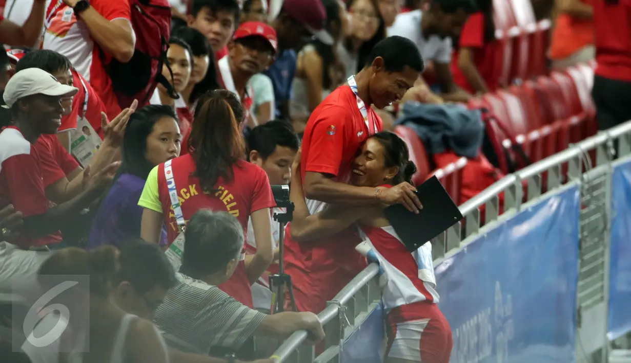 Atlet lompat jauh Indonesia, Maria Londa berhasil meraih emas di nomor lompat jauh putri SEA Games 2015 di National Stadium, Singapura, (10/6/2015). Maria memeluk pelatihnya usai memastikan meraih emas SEA Games 2015. (Liputan6.com/Helmi Fithriansyah)