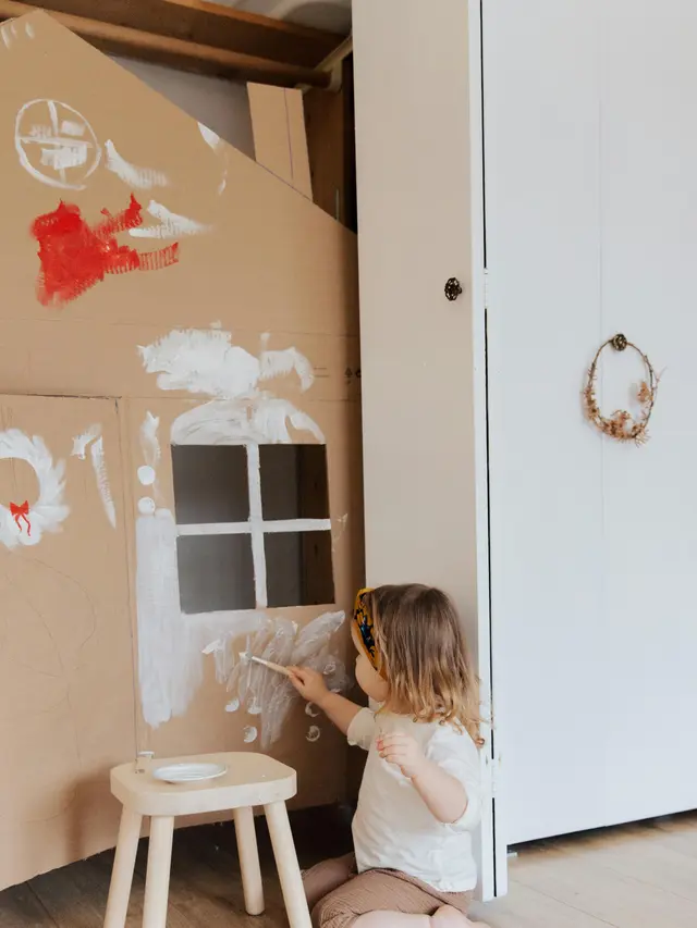 Anak menggambar di kardus