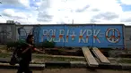 Seorang laki-laki melintas di depan mural di sisi Jalan Juanda, Depok, Jawa Barat. Foto diambil pada Senin (2/3/2015). (Liputan6.com/Helmi Fithriansyah)