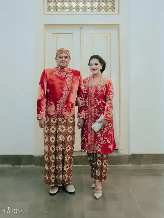 Ini adalah momen kebersamaan Kahiyang Ayu dan Bobby Nasution di pernikahan Kaesang Pangarep-Erina Gudono. Keduanya mengenakan busana adat Jawa. Kahiyang tampil mengenakan kebaya kutubaru velvet merah dihiasi bordir berpayet emas, serasi dengan beskap yang dikenakan Bobby. Keduanya memadukan penampilan ini dengan kain batik yang seragam sebagai bawahan. [Foto: Instagram/ayanggkahiyang]