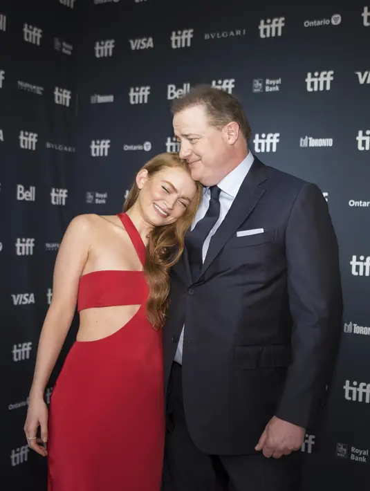 Sadie Sink memeluk aktor Brendan Fraser saat berpose di karpet merah saat pemutaran perdana film "The Whale" selama  Toronto International Film Festival (TIFF) di Royal Alexandra Theatre, di Toronto, Ontario, Minggu (11/9/2022). Sink memerankan Ellie, putri terasing dari karakter perang Fraser dalam film. (Tijana Martin/The Canadian Press via AP)