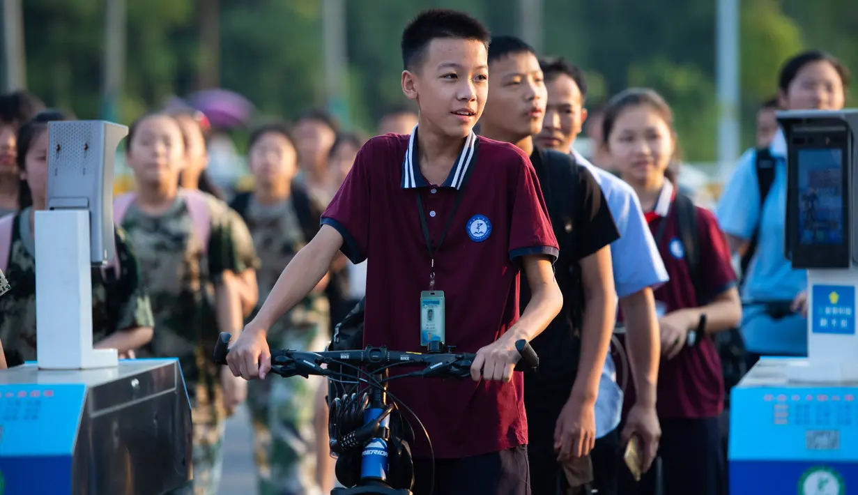 Para pelajar antre untuk memasuki Sekolah Menengah Daowu di Kota Liuyang di Changsha, ibu kota Provinsi Hunan, China, 31 Agustus 2020. Sekolah dasar dan menengah di Changsha memulai semester baru dengan menerapkan kebijakan pengendalian dan pencegahan COVID-19 yang ketat. (Xinhua/Chen Sihan)