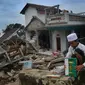 Seorang santri menyelamatkan Al-Qur'an dari puing banguan yang hancur akibat gempa di Pesantren Al Burok, Kampung Cisarua, Desa Sarampad, Cianjur, Jawa Barat, Rabu (21/11/2022). Gempa bumi dengan magnitude 5,6 di Cianjur Jawa Barat yang berpusat di darat 10 km barat daya embuat sejumlah rumah dan bangunan rusak. (merdeka.com/Arie Basuki)