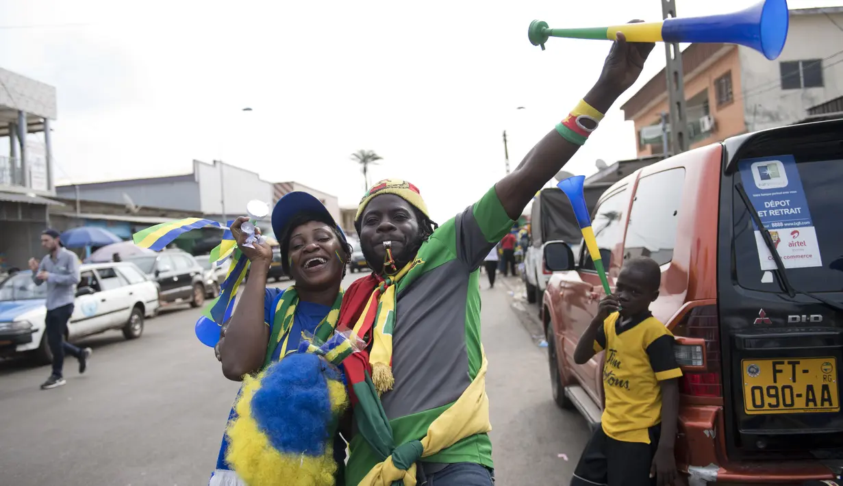 Pedagang Merchandise beraksi saat di foto sedang berjualan di jalanan kota Port-Gentil (18/1/2017). Pemandangan ini menjadi bagian dari penyeleggaraan Piala Afrika 2017. (AFP/Justin Tallis)