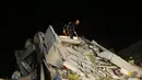 Anggota layanan penyelamatan mencari orang-orang yang selamat di puing-puing bangunan yang runtuh di Izmir, Turki, Sabtu (31/10/2020). Gempa bumi yang kuat melanda pada hari Jumat di Laut Aegea antara pantai Turki dan pulau Samos di Yunani, menewaskan beberapa orang. (AP Photo/Emrah Gurel)