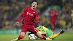 Gelandang Norwich City Pierre Lees-Melou melanggar gelandang Liverpool Curtis Jones pada babak ketiga Piala Liga Inggris di Carrow Road, Rabu (22/9/2021) dinihari WIB. Liverpool sukses menghajar Norwich City tiga gol tanpa balas di kandang lawan. (Joe Giddens/PA via AP)
