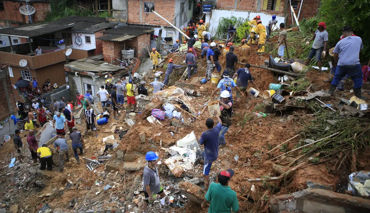 Petugas pemadam kebakaran dan warga mencari korban di dekat rumah yang hancur akibat tanah longsor setelah hujan lebat di Franco da Rocha, negara bagian Sao Paulo, Brasil  (30/1/2022). (AP Photo/Orlando Junior-Futura Press)