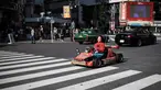 Seorang wanita mengendarai go-kart di persimpangan Shibuya di Tokyo, Jepang (23/5/2019). Shibuya adalah salah satu distrik khusus kota Tokyo, Jepang. Distrik kota ini didirikan pada 15 Maret 1947. (AFP Photo/Behrouz Mehri)
