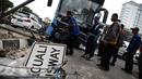 Petugas mengevakuasi bus gandeng TransJakarta yang menabrak pagar pembatas jalan, di Jalan Gunung Sahari, Jakarta, Selasa (6/9). Tak ada korban jiwa dalam insiden yang diduga lantaran sopir mengantuk tersebut. (Liputan6.com/Faizal Fanani)