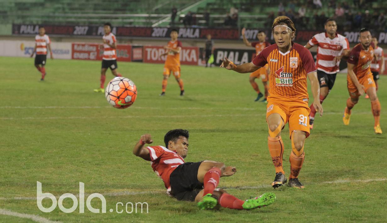 Pemain Pusamania Borneo FC, Michael Ora (kanan) menghadang pemain Madura United  pada babak delapan besar Piala Presiden 2017 di Stadion Manahan, Solo. Jumat (25/2/2017). (Bola.com/Nicklas Hanoatubun)