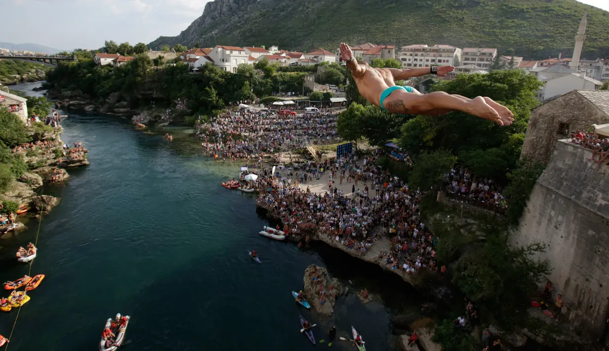 Peserta melompat dari Jembatan Old Mostar pada kompetisi menyelam tradisional ke-452 di Mostar, Bosnia, 29 Juli 2018. Penyelam berlari sebelum melompat dari jembatan, jatuh ke sungai dan terbang di udara seperti burung melakukan trik. (AP/Amel Emric)