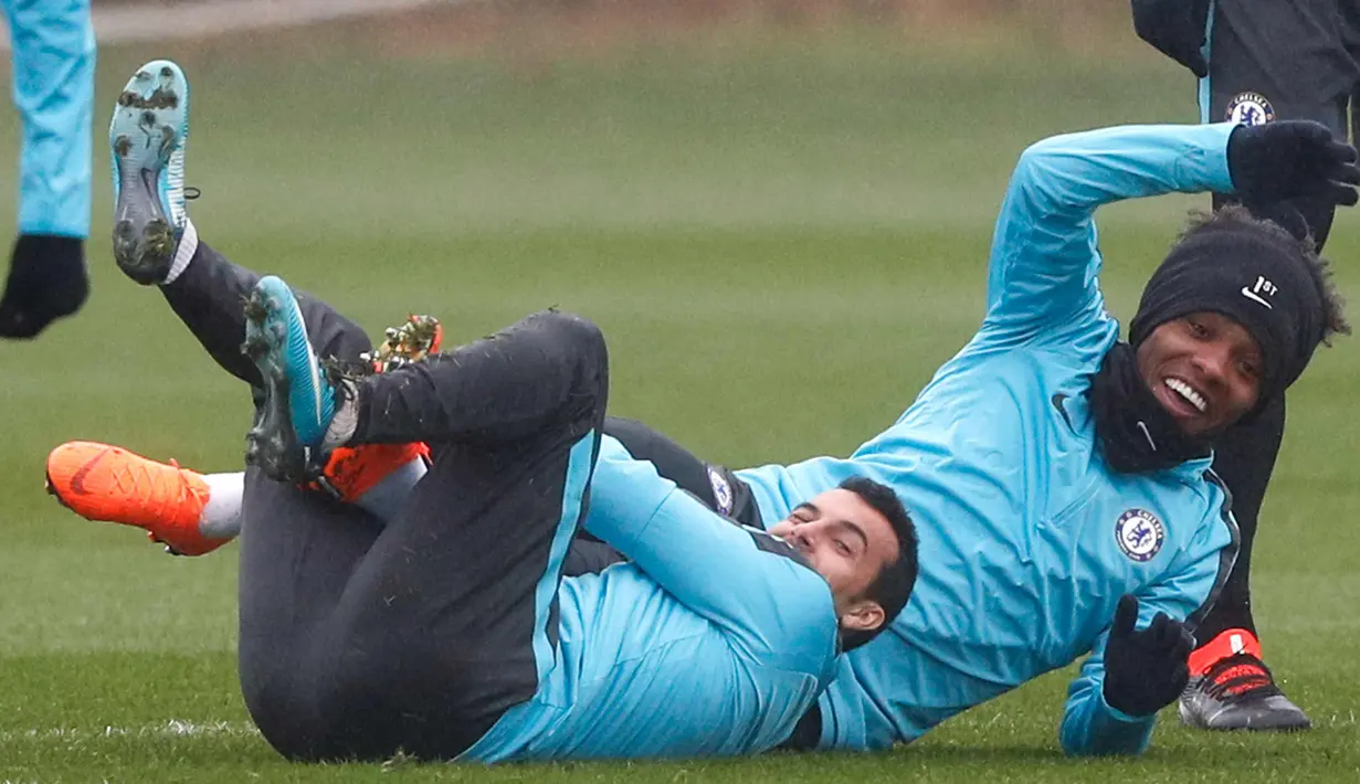 Penyerang Chelsea, Pedro (kiri) dan gelandang Willian saat mengikuti latihan di fasilitas latihan Chelsea Cobham di Stoke D'Abernon, London (19/2). Chelsea akan bertanding pada babak 16 besar Liga Champions melawan Barcelona. (AFP Photo/Adrian Dennis)