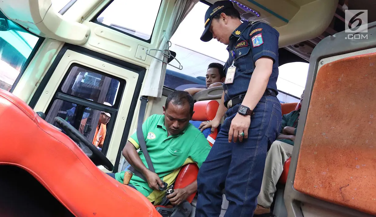 Petugas Dishub DKI Jakarta mengecek sabuk pengendara sopir bus jelang mudik Lebaran di Terminal Kampung Rambutan, Jakarta, Jumat (8/6). Menurut Dishub, dari 37 bus yang dicek ada 26 dinyatakan tidak lulus uji kelaikan. (Liputan6.com/Immanuel Antonius)