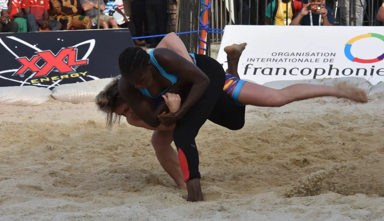 Linquararu Madalina dari Rumania bertarung dengan Binette Diata dari Senegal dalam pertarungan individu 50kg Pertarungan Wanita Gulat Tradisional selama Francophonie ke-8 di Treichville Sports Park di Abidjan pada 29 Juli 2017. (AFP Photo/Sia Kambou)