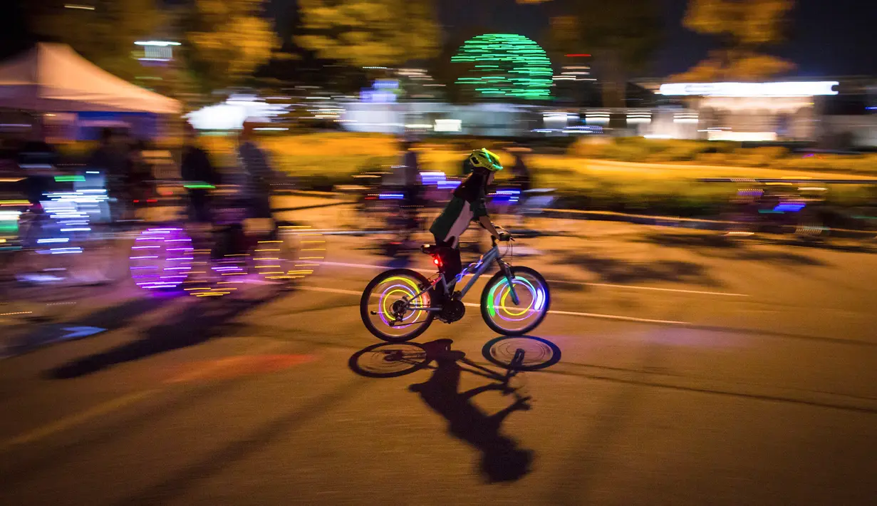 Seorang peserta mengendarai sepedanya dengan hiasan lampu saat berpartisipasi dalam acara Bike the Night di Vancouver, BC, (16/9). Penyelenggara mengharapkan lebih dari 5.000 orang untuk berpartisipasi dalam acara ini. (Darryl Dyck/Canadian Press via AP)