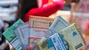 Warga memperlihatkan pecahan uang tunai baru di layanan kas keliling Bank Indonesia di Pasar Kopro, Jakarta Barat, Rabu (29/3/2023). (Liputan6.com/Angga Yuniar)