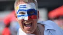 Seorang suporter mengecat wajahnya dengan bendera Uruguay dan Rusia jelang laga kedua negara dalam penyisihan Grup A Piala Dunia 2018 di Samara Arena, Samara, Rusia, Senin (25/6). (EMMANUEL DUNAND/AFP)