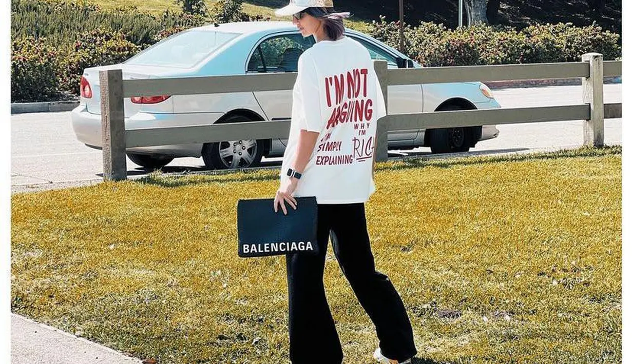 Gayanya dipuji bak artis Hollywood oleh artis Marshanda, ibu tiga anak ini tampil chic bak anak muda memadukan oversized t-shirt warna putih dengan black long pants berpotongan cutbray serta clutch Balenciaga. (Instagram/ramadhaniabakrie).