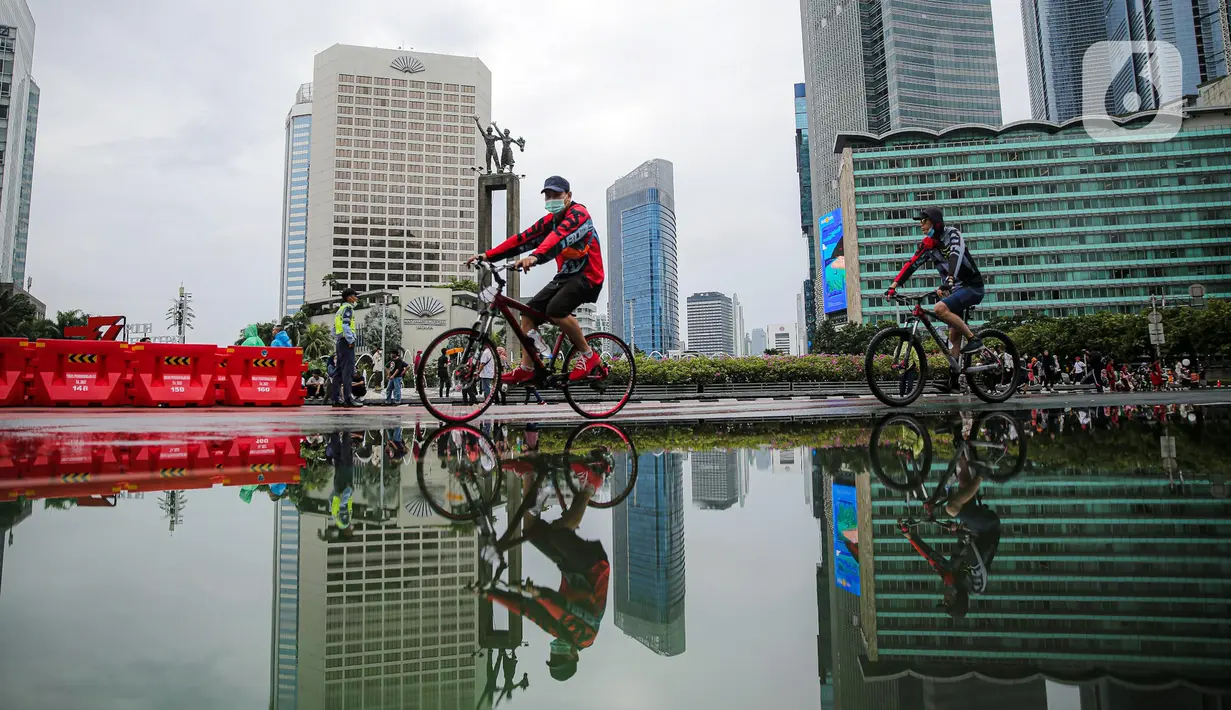 Warga bersepeda saat Car Free Day (CFD) di kawasan Bundaran HI, Jakarta, Minggu (2/10/2022). Meski diguyur hujan deras sejak pagi, warga tetap antusias untuk tetap berolahraga saat CFD. (Liputan6.com/Faizal Fanani)