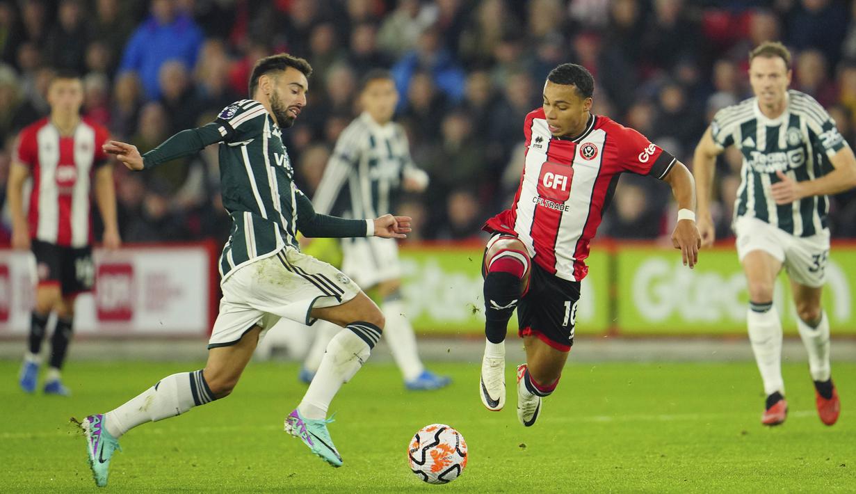 Pemain MU, Bruno Fernandes (kiri), dan pemain Sheffield United, Cameron Archer, berusaha merebut bola dalam laga pekan ke-9 Premier League 2023/2024 yang berlangsung di Bramall Lane, Inggris, Minggu (22/10/2023). (AP Photo/Jon Super)