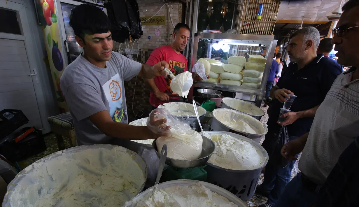 Seorang pedagang menjual yogurt di pasar populer di Baghdad, Irak (24/5/2019). Baghdad adalah kota terbesar kedua di Asia Barat Daya setelah Teheran, dengan populasinya pada 2003 diperkirakan mencapai 5.772.000. (AFP Photo/Ahmad Al-Rubaye)