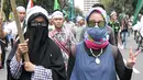 Dua demonstran perempuan mengikuti aksi damai sambil berjalan kaki di Jalan Medan Merdeka Selatan, Jakarta, Jumat (4/11). Ratusan ribu massa aksi damai melakukan aksi menuntut penegakan hukum kasus dugaan penistaan agama. (Liputan6.com/Yoppy Renato)