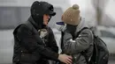 Seorang pengungsi yang melarikan diri dari Ukraina menyeka air mata setelah melihat seorang kerabat di perbatasan Rumania-Ukraina, di Siret, Rumania, Senin, 7 Maret 2022. (AP Photo/Andreea Alexandru)