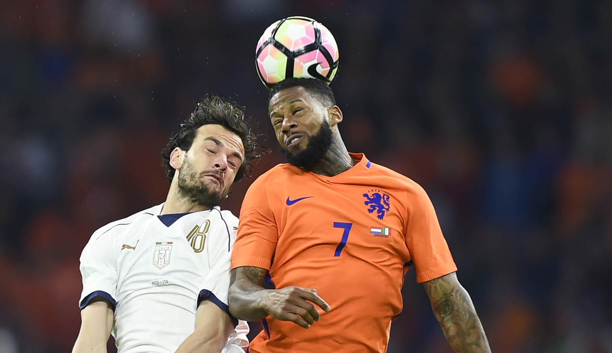 Gelandang Italia, Marco Parolo, duel udara dengan striker Belanda, Jeremain Lens. Belanda sebenarnya tampil lebih mendominasi dengan penguasaan bola hingga 56 persen sedangkan Italia hanya 44 persen. (AFP/John Thys)