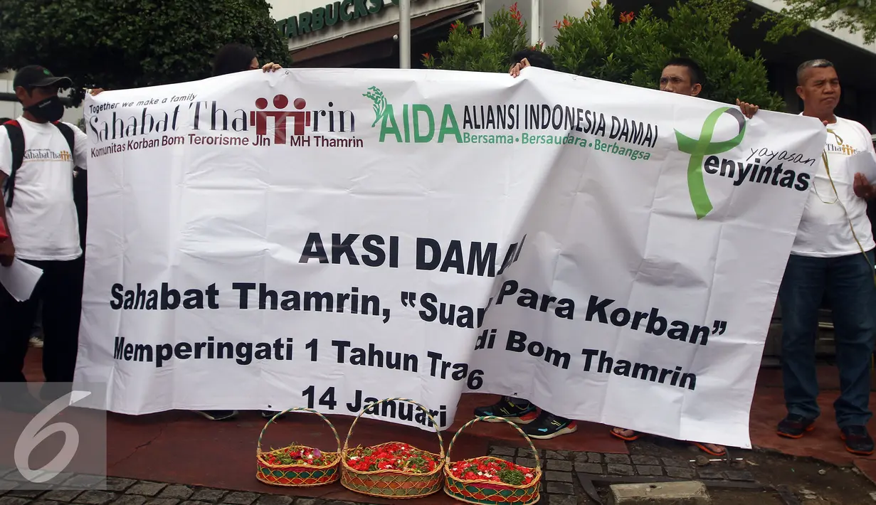 Sejumlah orang melakukan aksi sambil membawa spanduk saat "Peringatan 1 Tahun Tragedi Bom Thamrin 14 Januari 2016" di Pos Polisi di MH Thamrin, Sarinah, Jakarta, Sabtu (14/1). (Liputan6.com/JohanTallo)