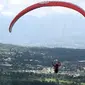 Seorang paraglider lepas landas dari lereng bukit di Puncak, Bogor, Jawa Barat, Kamis (2/12/2021). Destinasi wisata alam Bukit Paralayang Puncak Bogor sangat cocok untuk dikunjungi pada liburan akhir pekan bersama keluarga, sahabat maupun pasangan tercinta. (Goh Chai Hin/AFP)