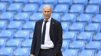 Pelatih Real Madird, Zinedine Zidane menyaksikan pemainnya bertanding melawan Manchester City pada leg kedua babak 16 besar Liga Champions di Etihad Stadium, Inggris (7/8/2020). City menang tipis 2-1 dan melaju ke perempat final unggul agregat 4-2 atas Madrid. (Peter Powell/Pool Photo via AP)