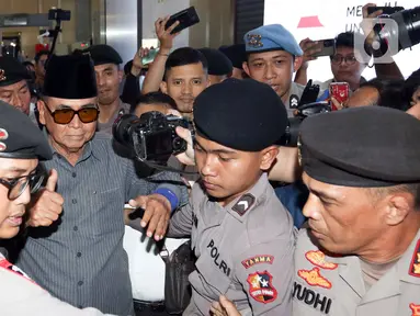 Pemimpin Pondok Pesantren Al Zaytun Panji Gumilang (kopiah hitam) mengacungkan jempol saat tiba di Bareskrim Polri, Jakarta, Selasa (1/8/2023). Panji Gumilang memenuhi panggilan pemeriksaan penyidik Direktorat Tindak Pidana Umum Bareskrim Polri terjait dugaan penistaan agama. (Liputan6.com/Herman Zakharia)