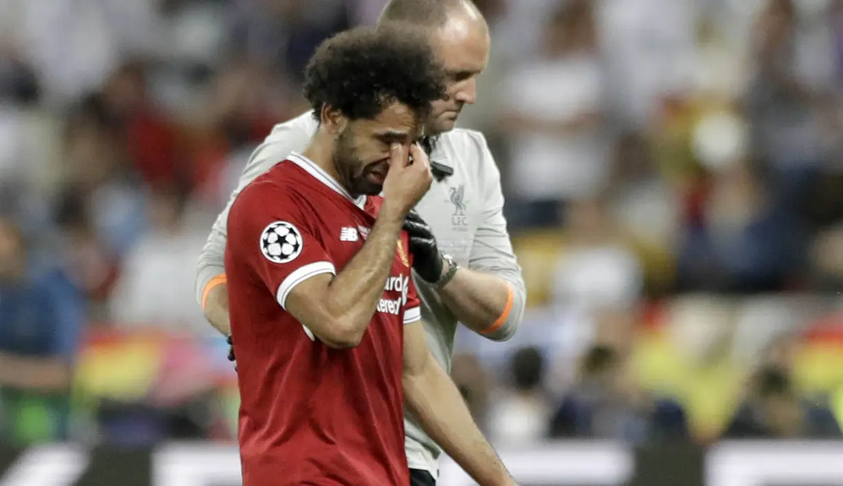 Striker Liverpool, Mohamed Salah, menangis saat ditarik keluar lapangan pada laga final Liga Champions di Stadion NSC Olimpiyskiy, Kiev, Minggu (27/5/2018). Salah mengalami cedera bahu usai dilanggar Ramos. (AP/Matthias Schrader)