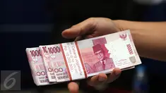 Petugas memperlihatkan barang bukti uang palsu pecahan Rp 100.000,- saat rilis di Bareskrim Mabes Polri, Gedung KKP, Jakarta, Senin (10/10). Peredaran dikendalikan dari rutan, empat tersangka diamankan dalam kasus ini. (Liputan6.com/Helmi Fithriansyah)