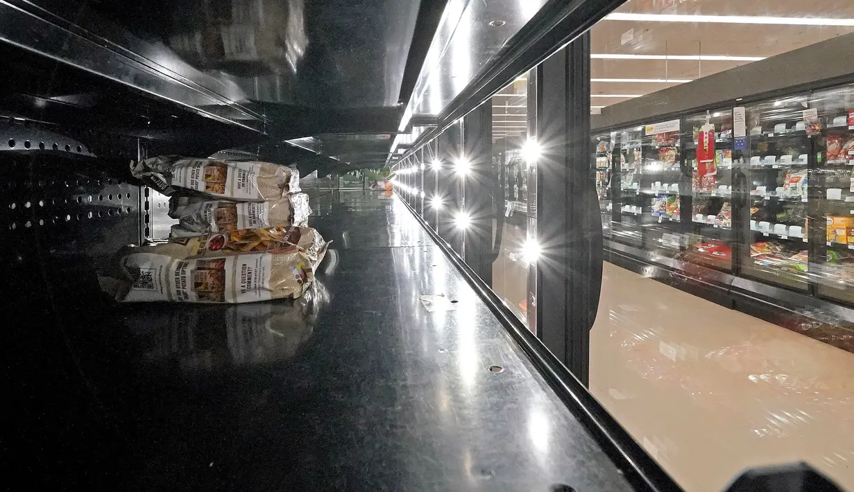 Pendingin makanan beku kosong di sebuah toko kelontong di Pennsylvania, Selasa (11/1/2022). Varian Omicron yang sangat menular membuat pekerja sakit, menciptakan kekurangan tenaga kerja yang memengaruhi pengiriman produk dan pengisian kembali rak-rak toko di seluruh negeri. (AP Photo/Gene J. Puskar)