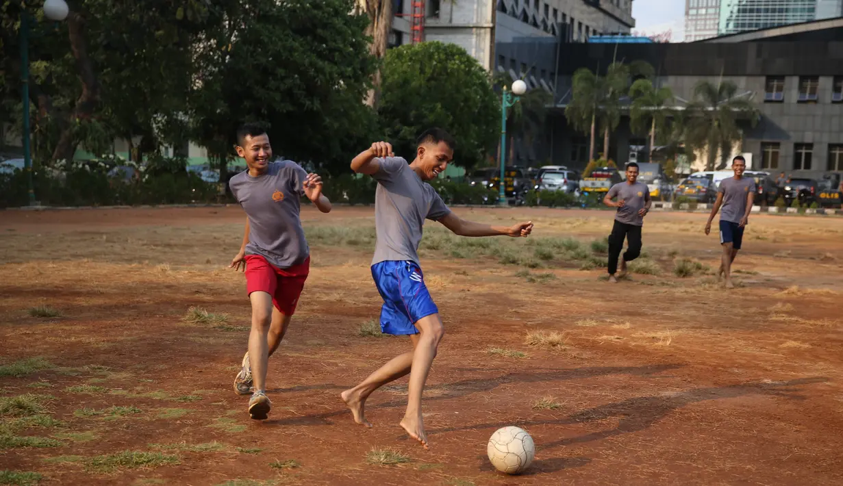 Polisi dari kesatuan Sabhara merenggangkan otot dengan bermain bola di Kawasan Polda Metro, Jakarta, Selasa (13/10/2015). Pihak Kepolisian dan TNI bersiap siaga menjelang laga Final Piala Presiden 2015. (Bola.com/Nicklas Hanoatubun).