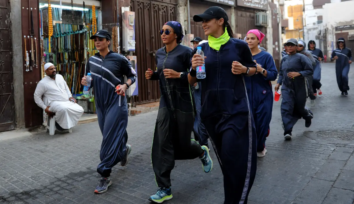 Perempuan Arab Saudi jogging di jalanan Distrik Al-Balad, Jeddah, Kamis (8/3). Aksi ini dilakukan dalam memperingati Women's Day atau Hari Perempuan Internasional. (Amer HILABI/AFP)