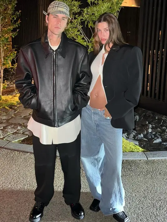 Keduanya mengubah penampilan mereka untuk foto kedua. Baby bump Hailey mengintip dari balik blus putih-nya. Penampilannya dipadukan dengan jas hitam dan low rise jeans.   Begitu juga dengan Justin yang tampak mengenakan kemeja putih di bawah jaket kulit hitamnya. [@haileybieber/@justinbieber]