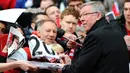 Pelatih Manchester United, Sir Alex Ferguson, memberikan tandan tangan kepada fans saat melawan Swansea City pada laga Premier League di Stadion Old Trafford (12/5/2013). Pertandingan tersebut sekaligus menjadi momen perpisahan Sir Alex Ferguson bersama Setan Merah. (AFP/Andrew Yates)