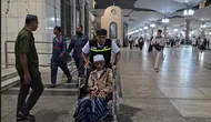 Petugas haji mengantar pulang jemaah haji lansia dari Masjid Nabawi menuju hotel menggunakan kursi roda. (FOTO: MCH PPIH ARAB SAUDI 2023)