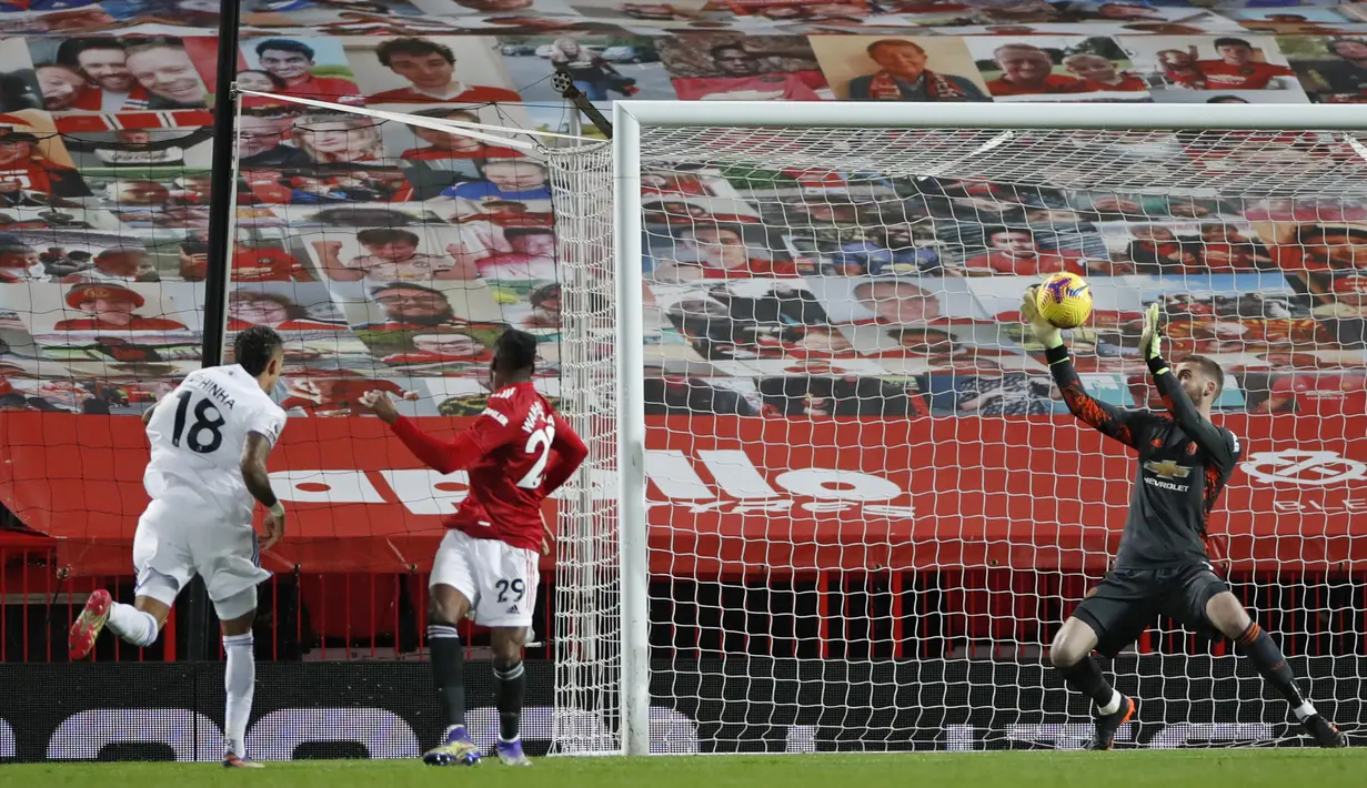 Kiper Manchester United, David de Gea, menepis tendangan striker Leeds United, Raphinha (kiri), dalam laga lanjutan Liga Inggris 2020/21 pekan ke-14 di Old Trafford Stadium, Minggu (20/12/2020). Manchester United menang 6-2 atas Leeds United. (AFP/Clive Brunskill/Pool)