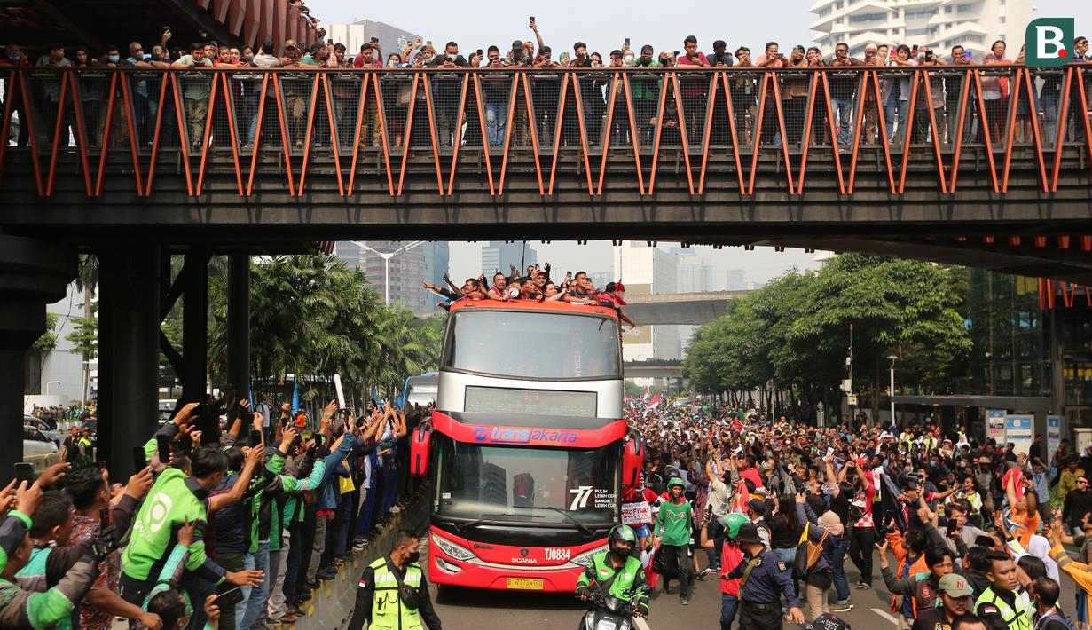Bus yang ditumpangi Timnas Indonesia U-22 melewati Jembatan Penyeberangan Orang Karet (Jembatan Phinisi) saat pawai kontingen Indonesia untuk SEA Games 2023 yang bertajuk Kira87uara yang berlangsung di Jakarta, Jumat (19/05/2023). (Bola.com/Bagaskara Lazuardi)