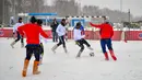 Para pemain berebut bola saat pertandingan persahabatan antara wartawan dan mahasiswa asing di lapangan bersalju di Nizhny Novgorod, Rusia, Minggu (21/1). Dalam pertandingan ini para pemain mengenakan sepatu tradisional Rusia. (AFP PHOTO/Mladen ANTONOV)