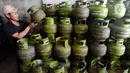Pekerja menyusun Gas 3 kilo di Pangkalan Elpiji 3 kilo di Jalan Munawarman, Ciputat, Tangerang Selatan, Banten, Senin (16/1/2023). Sejumlah pekerja pangkalan elpiji belum mengetahui uji coba pembelian elpiji subsidi menggunakan KTP. Sejauh ini, Kementerian ESDM bersama Pertamina masih melakukan uji coba pembelian elpiji 3 kg dengan menunjukkan KTP di lima kecamatan, yakni Cipondoh di Kota Tangerang, Ciputat di Tangerang Selatan, Ngaliyan di Semarang, Batu Ampar di Batam, dan Kecamatan Mataram di Mataram. (merdeka.com/Arie Basuki)