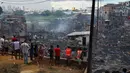 Sejumlah warga melihat sisa-sisa rumah yang hangus di lingkungan Educandos di Manaus, Brasil (17/12). Para pihak berwenang mengatakan setidaknya 600 rumah kayu hanggus terbakar. (AP Photo/Edmar Barros)
