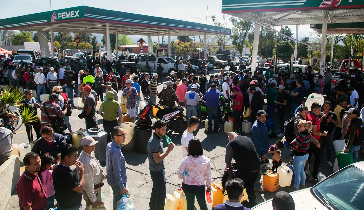 Antrean puluhan warga di tengah kelangkaan BBM di sebuah SPBU di Morelia, Meksiko, Selasa (8/1). Kelangkaan BBM tersebut akibat terjadinya pencurian dari jaringan pipa dan dari internal Pemex, perusahaan minyak milik negara. (ENRIQUE CASTRO/AFP)
