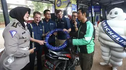 Presdir. PT Michelin Indonesia Pascal Nouvellon (ketiga kanan) dan Kasubdit Dikyasa Ditlantas Polda Metro Jaya AKBP Agustin Susilowati menunjukkan produk ban roda dua Michelin kepada pengendara, di Jakarta, Rabu (15/6). (Liputan6.com/Angga Yuniar)