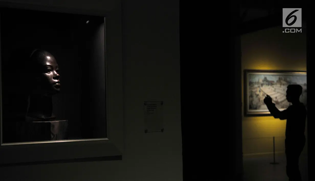Pengunjung mengabadikan salah satu patung karya Jean Daniel Guerry berjudul "Kepala Perempuan" yang dipamerkan di Galeri Nasional, Jakarta, Senin (6/8). (Merdeka.com/Iqbal Nugroho)