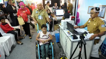 Seorang anak penderita Spina Bifida  bersiap melakukan pemotretan pembuatan kartu identitas anak (KIA) di  Lapangan Skadron 21 Sena Penerbad, Tangerang Selatan, Banten, Senin (25/11/2019). Sekitar 500 anak melakukan pembuatan KIA secara gratis. (merdeka.com/Arie Basuki)